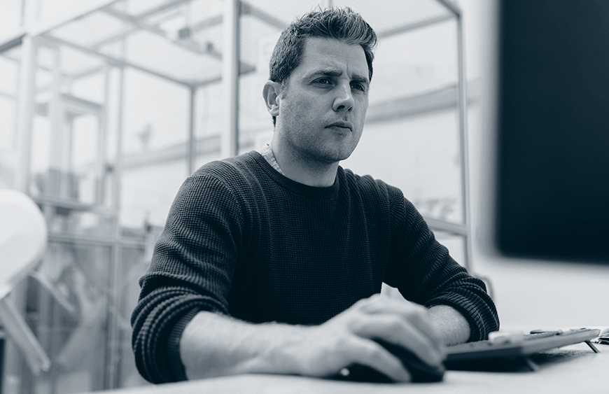 Konsentrert mann benytter versjonskontroll på PC.