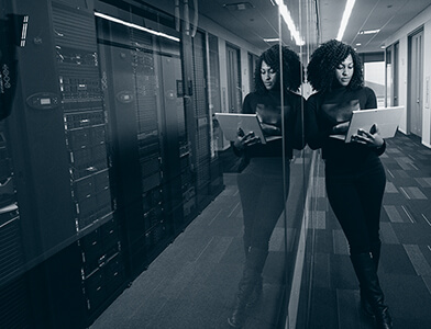Kvinne står ved siden av servere